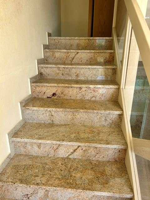 Elegante Treppe mit Granitstufen und moderner Glasbrüstung, die die Etagen verbindet.