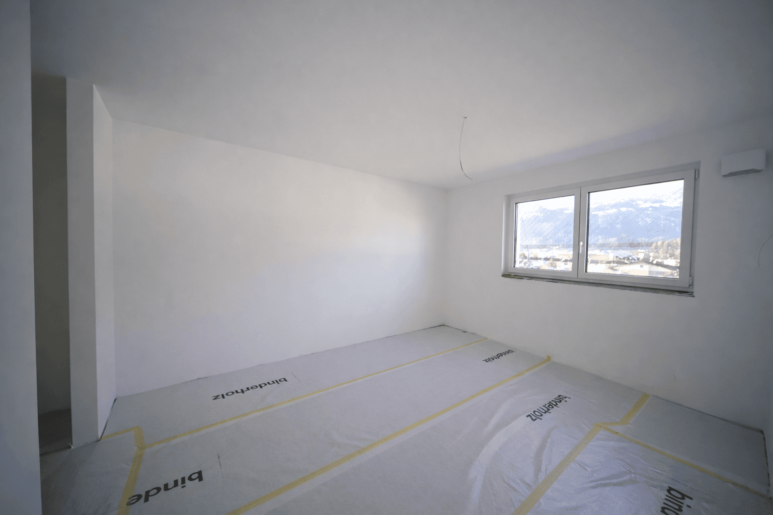 Unmöbliertes Schlafzimmer im Neubau mit Fenster und weitem Ausblick.