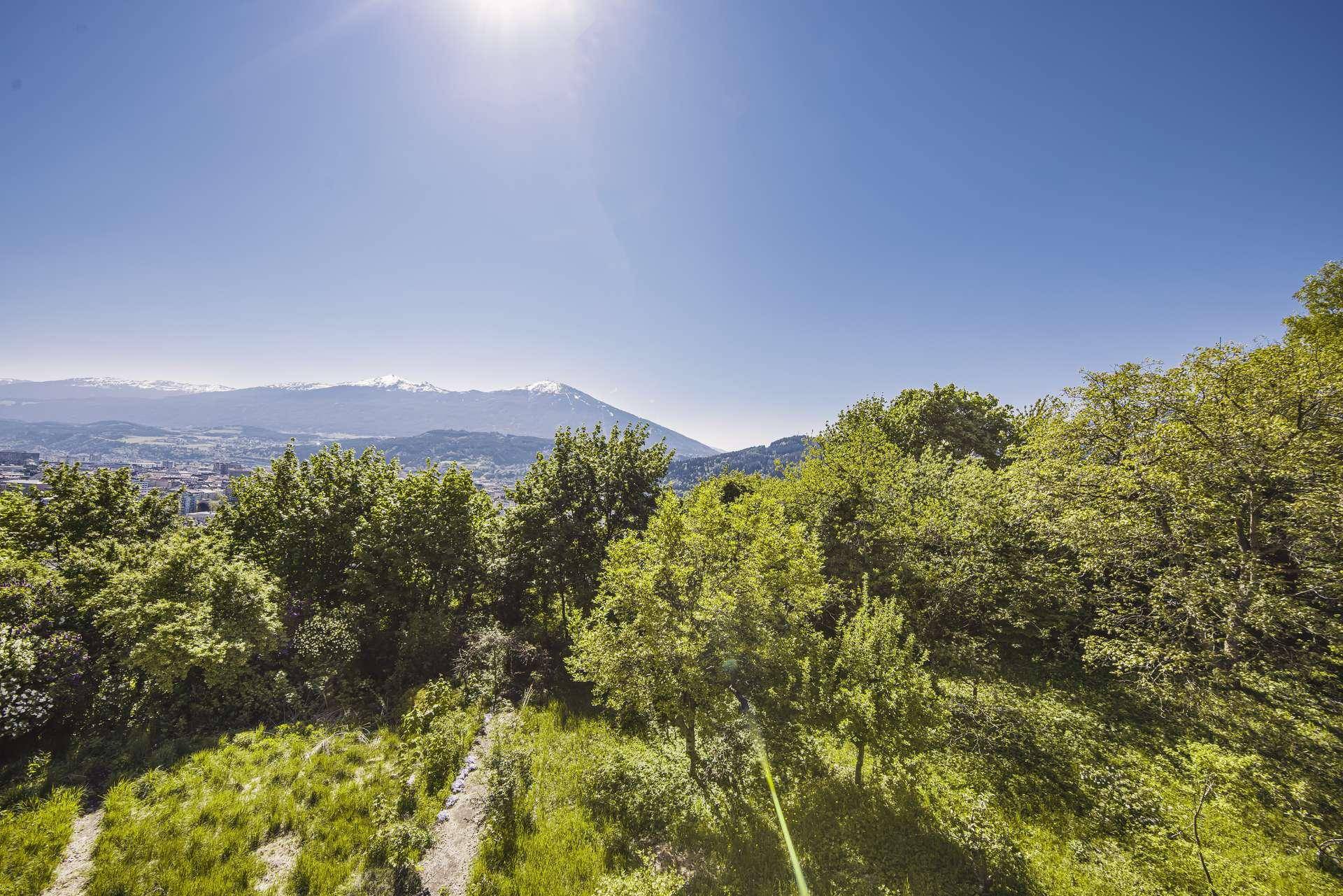 Herrlicher Panoramablick auf die Stadt und die umliegende Berglandschaft unter strahlend blauem Himmel.