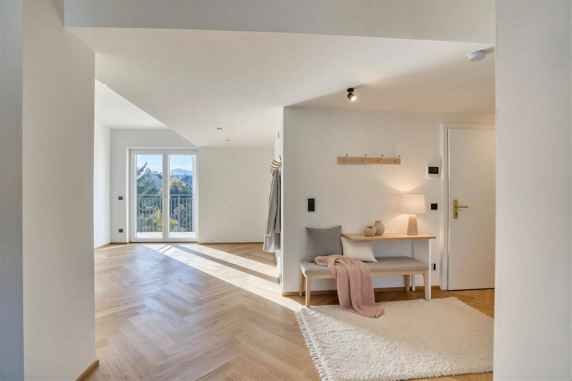 Heller Eingangsbereich mit Sitzbank, Garderobe und Zugang zu einem französischen Balkon.