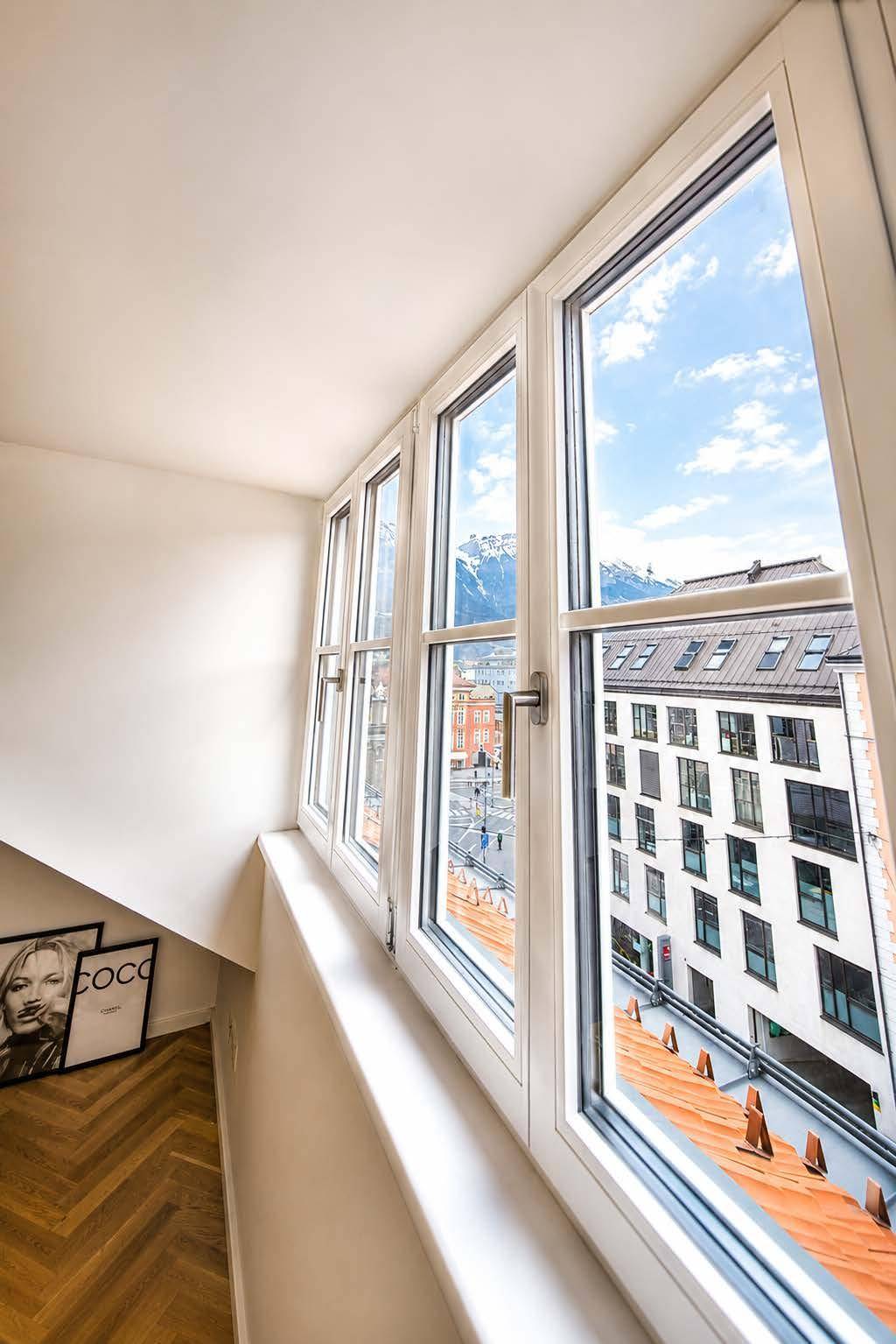 Heller Bereich mit großen Fenstern, die einen weiten Blick auf die Stadt und die Berge bieten.
