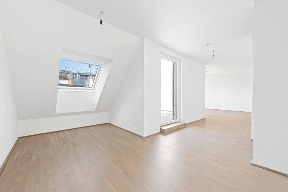 Geräumiger, heller Wohnbereich mit Dachfenster und direktem Zugang zur Außenterrasse.