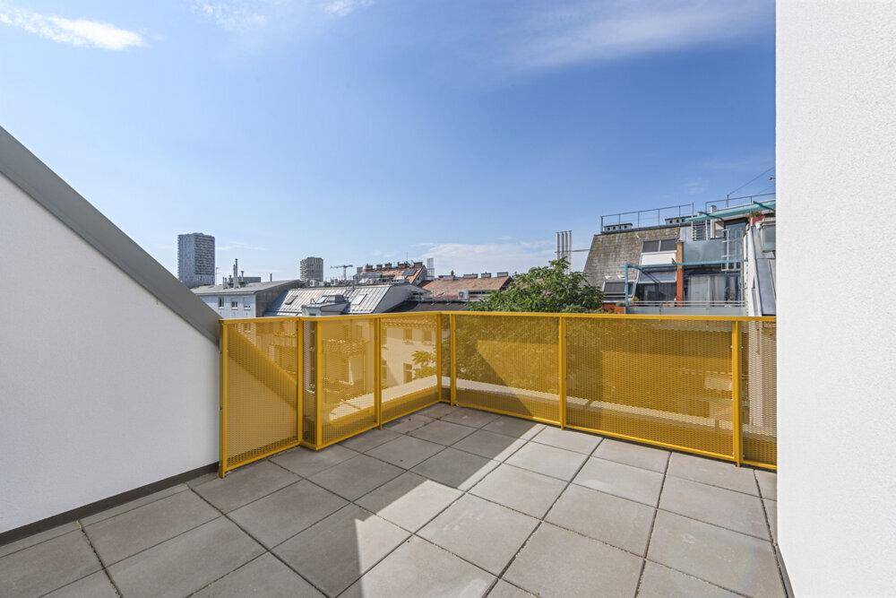 Weitläufige Dachterrasse mit gelbem Geländer und Panoramablick über die städtische Umgebung.