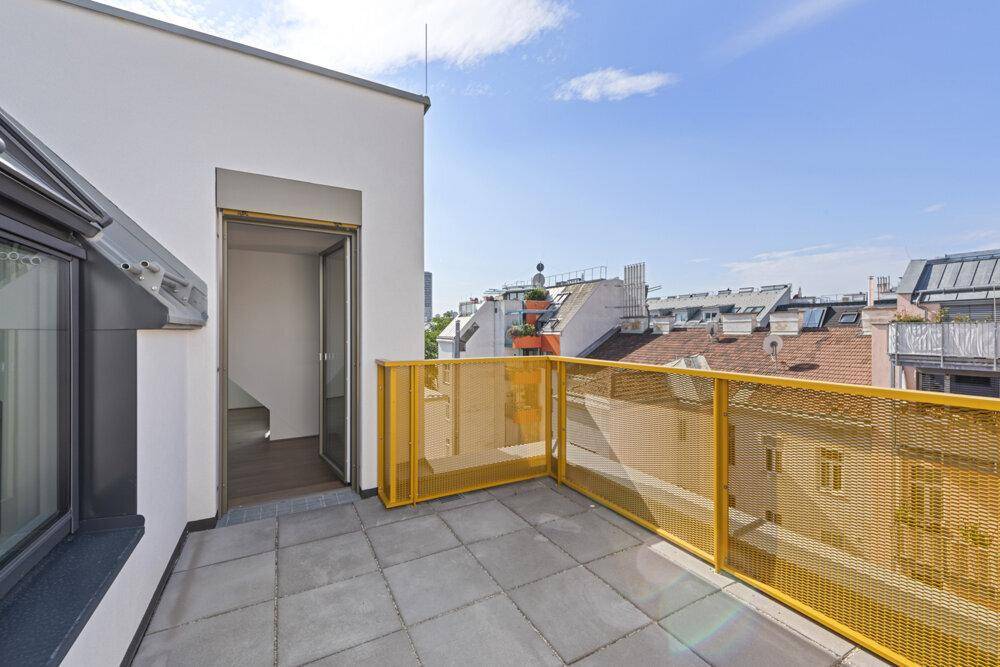 Dachterrasse mit Zugang zum Innenbereich und Blick über die Stadt.