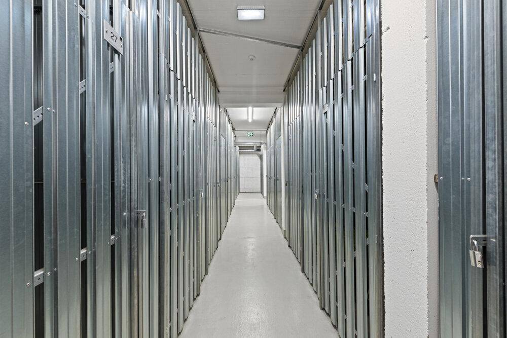 Langer Flur im Keller mit vielen individuellen Abstellräumen.