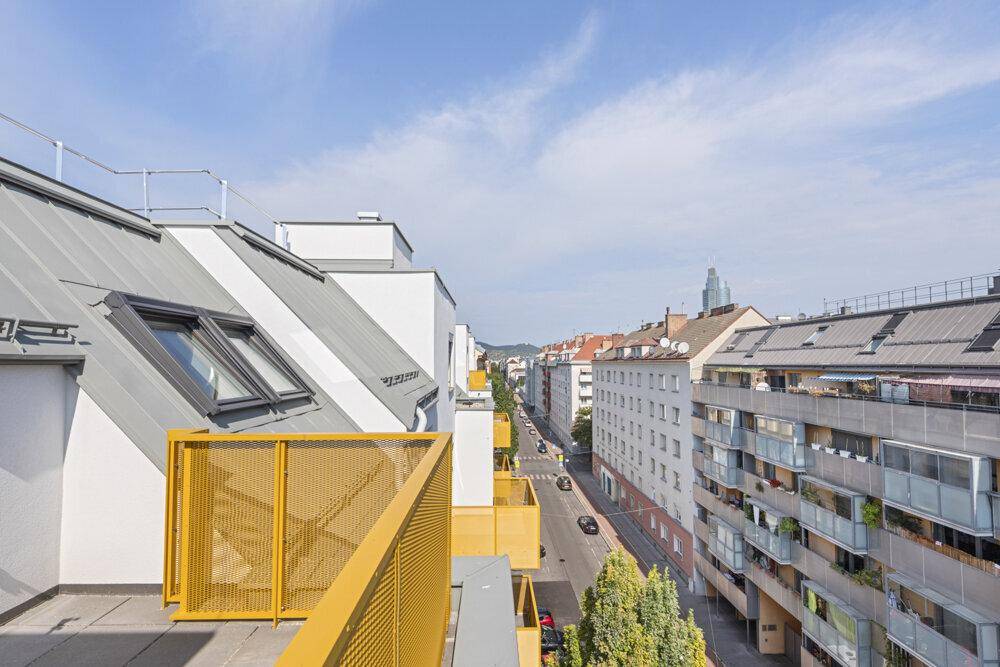 Ausblick von der Terrasse auf eine belebte Straße und die umliegende Stadtlandschaft.
