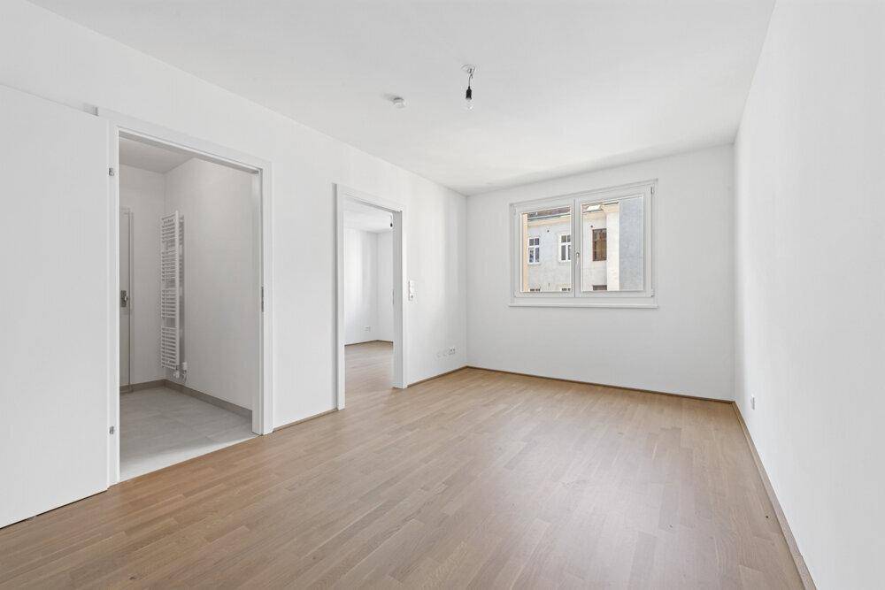 Heller Raum mit Parkettboden und Zugang zu weiteren Zimmern, ideal für individuelle Gestaltung.