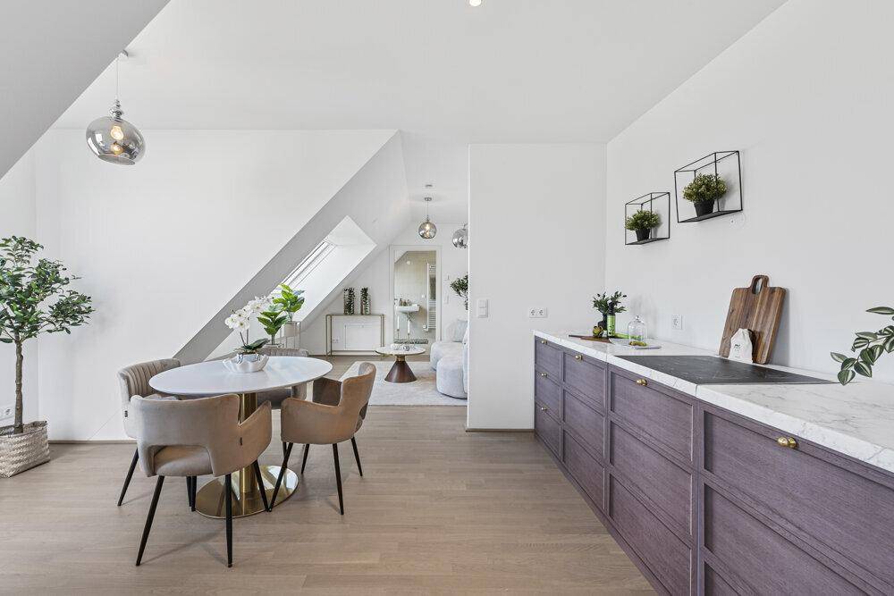 Moderne Wohnküche mit Essbereich, dunklen Schränken und Marmor-Arbeitsplatte.