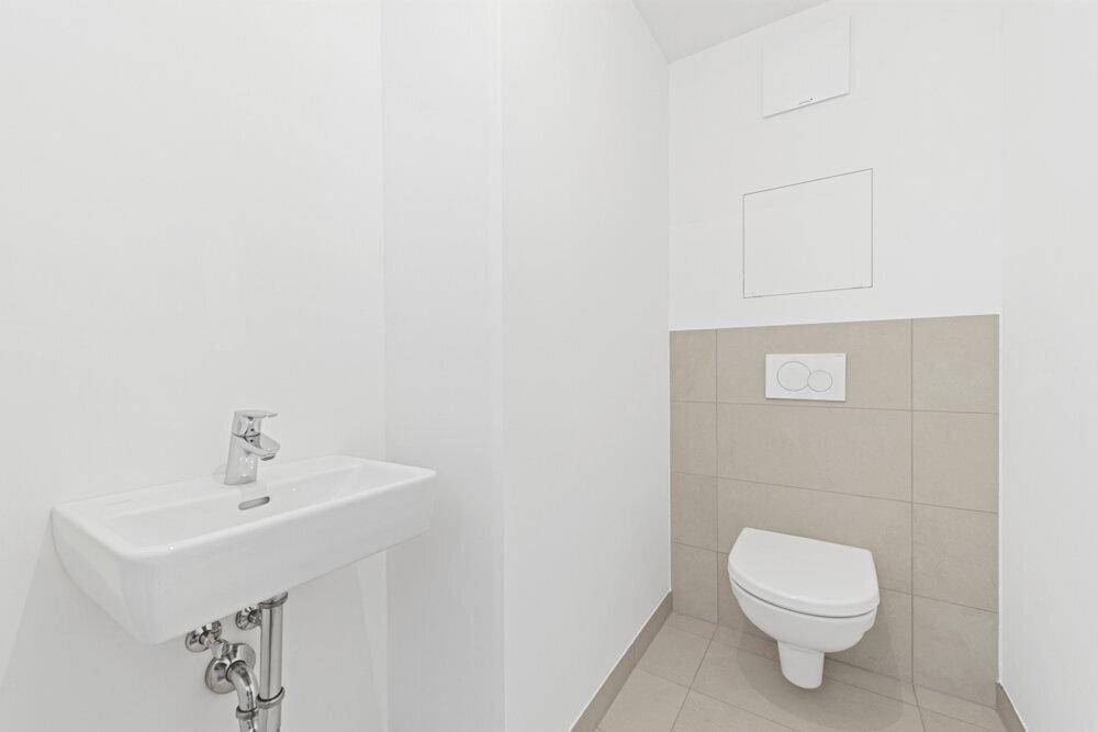 Kleines, modernes Gäste-WC mit wandhängender Toilette und Waschbecken in neutralen Farben.