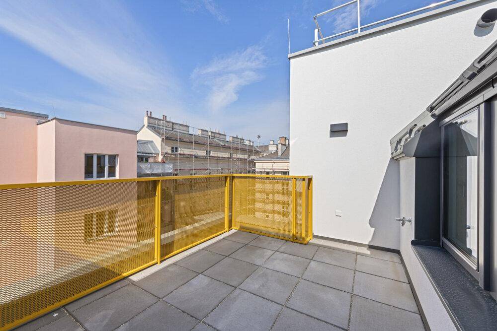 Geräumige Dachterrasse mit Fliesenboden und gelbem Geländer, ideal zum Entspannen.