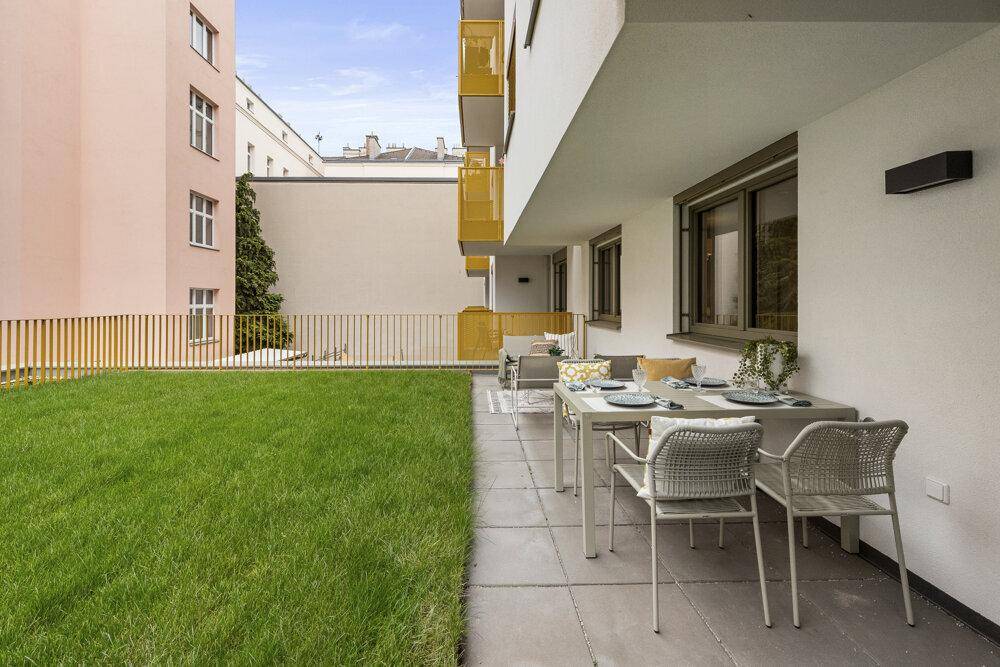 Geräumige Terrasse mit modernen Gartenmöbeln und direktem Zugang zum grünen Rasenbereich.