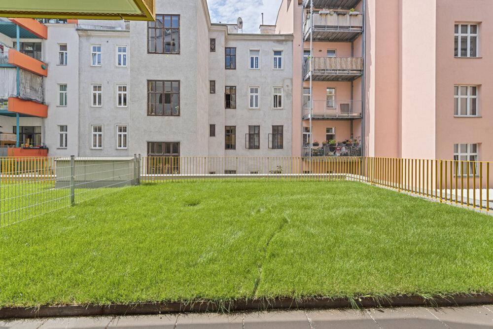 Gepflegte Rasenfläche im Innenhof, umgeben von Wohngebäuden.
