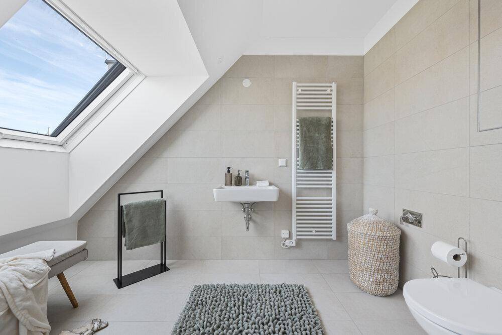Helles Badezimmer mit Dachfenster, modernem Waschtisch und Wand-WC.