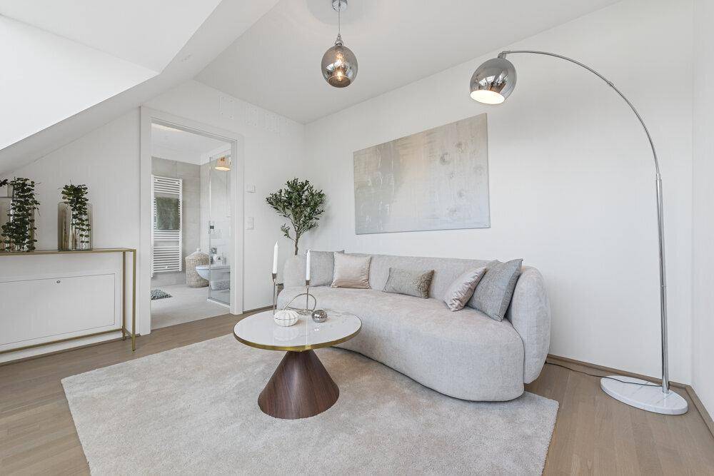 Geräumiges Wohnzimmer mit modernem Sofa, Stehlampe und Zugang zum Badezimmer.