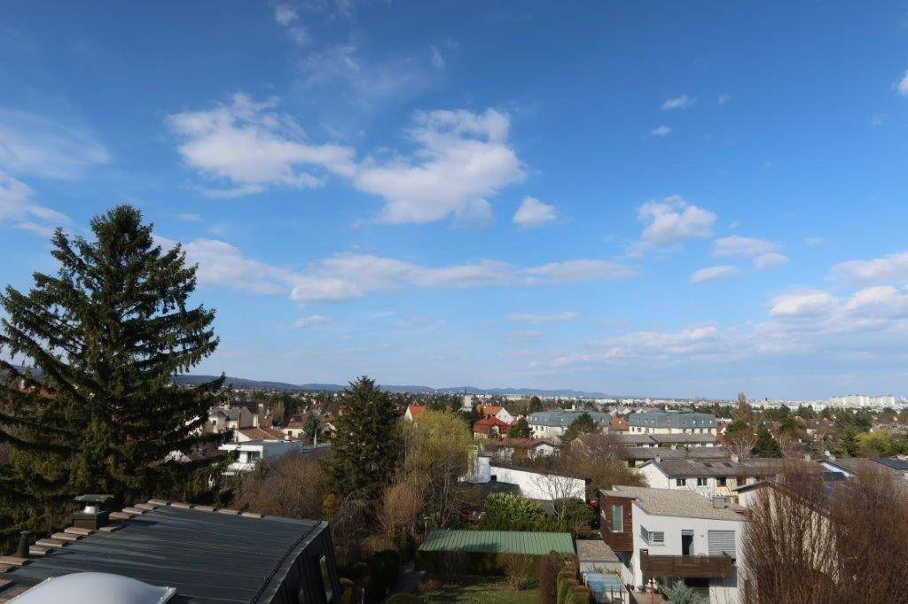 Panoramablick über die Stadt und die grüne Umgebung an einem sonnigen Tag.