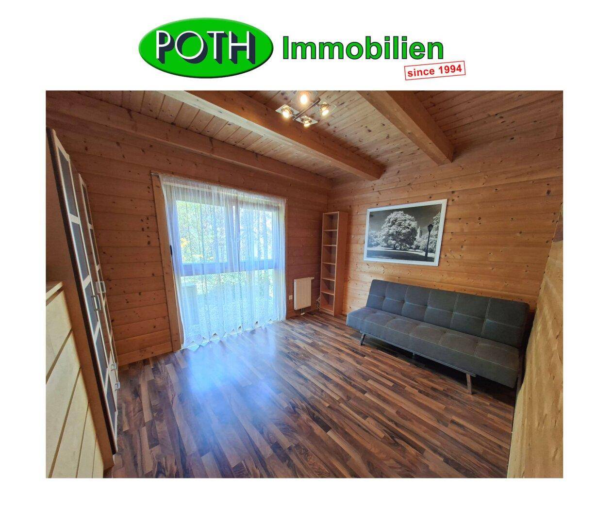 Schlafzimmer mit Holzwänden, Holzbalkendecke und Laminatboden, hell und freundlich.