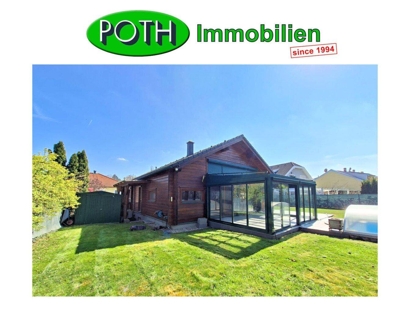 Holzhaus mit großem Garten, Pool und verglastem Wintergarten an einem sonnigen Tag.