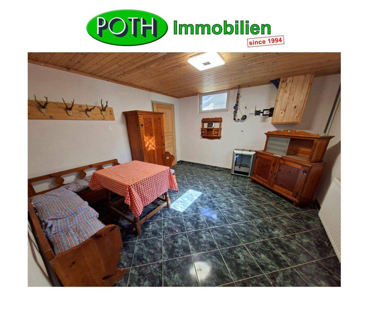 Rustikaler Kellerraum mit Holzbalkendecke, Fliesenboden und traditioneller Einrichtung.