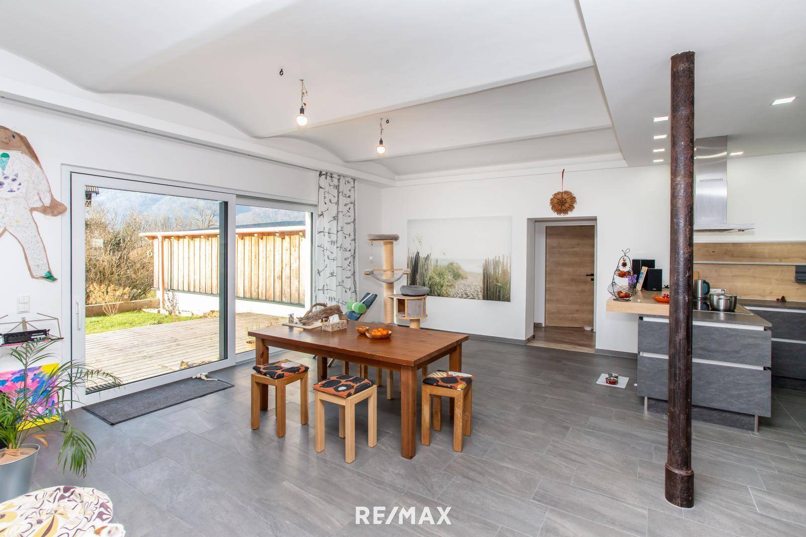 Essbereich mit Holztisch und Stühlen, direktem Zugang zur Terrasse und Blick ins Grüne.