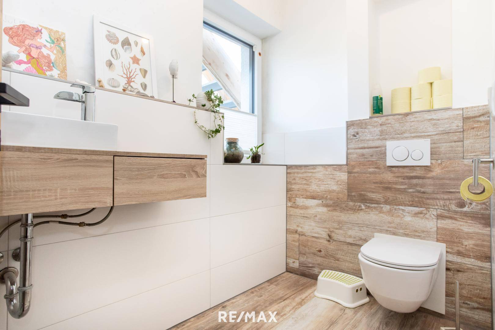 Modernes Gäste-WC mit Wand-WC, Waschbecken und Holzoptik-Fliesen.