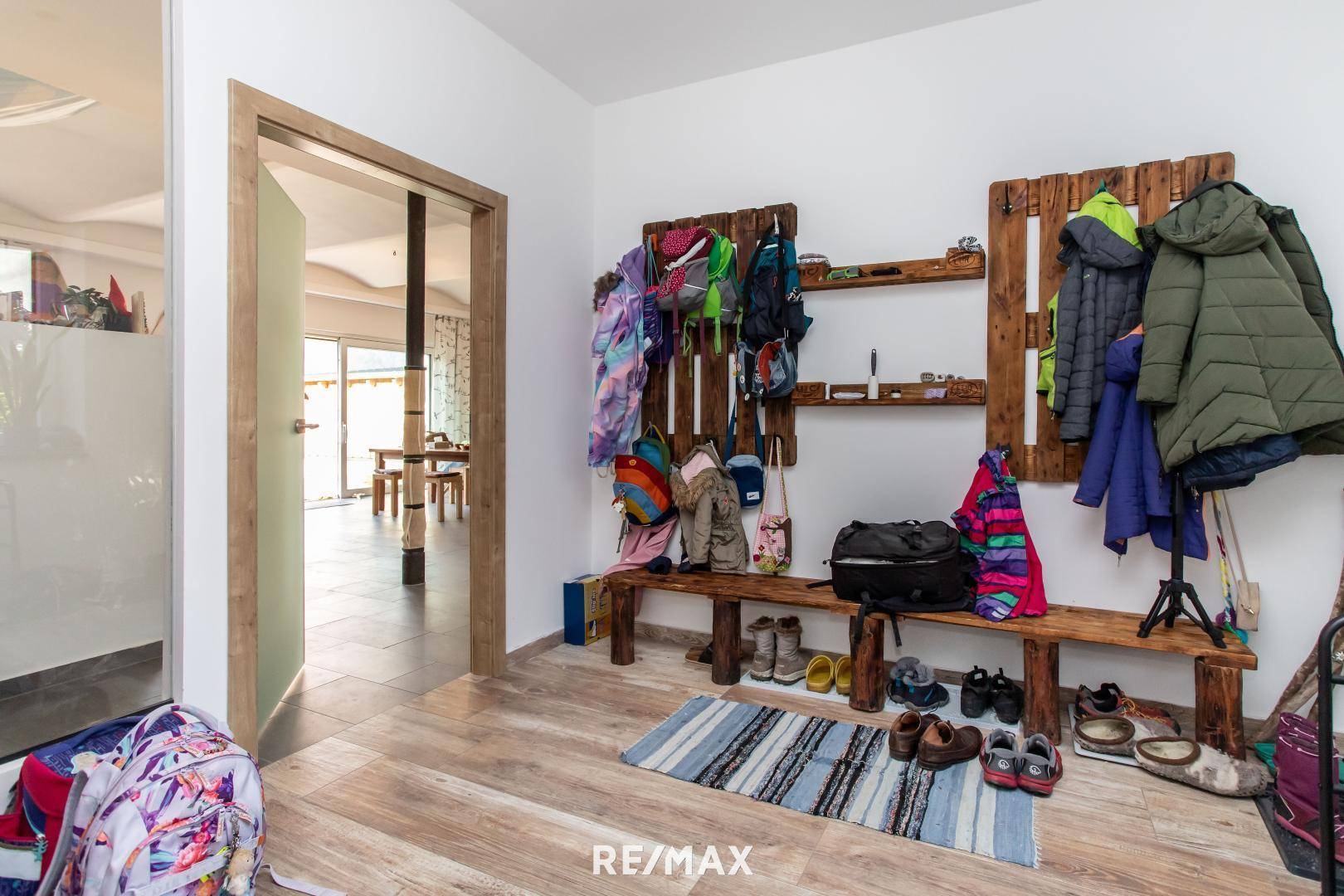 Eingangsbereich mit Garderobe aus Holzpaletten und hellem Laminatboden.