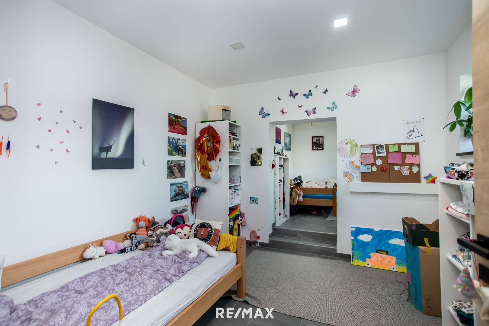 Kinderzimmer mit zwei Schlafbereichen auf unterschiedlichen Ebenen und kreativer Wandgestaltung.