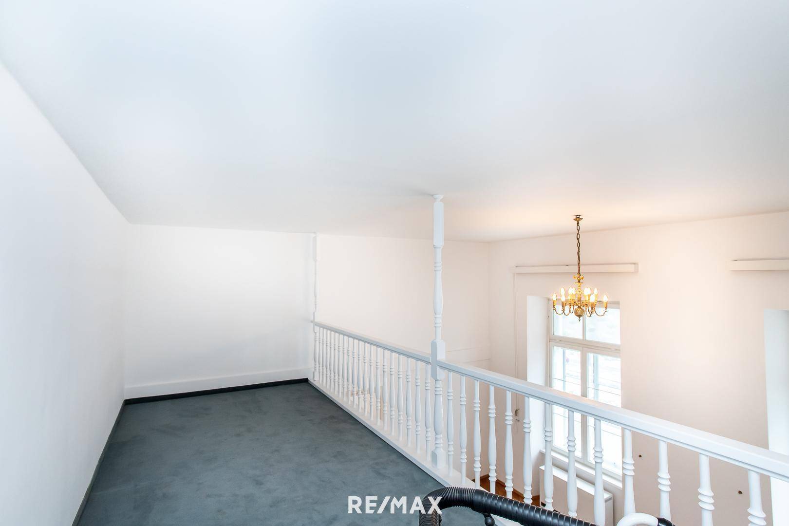 Obere Galerie mit Teppichboden und Blick auf den unteren Wohnbereich.