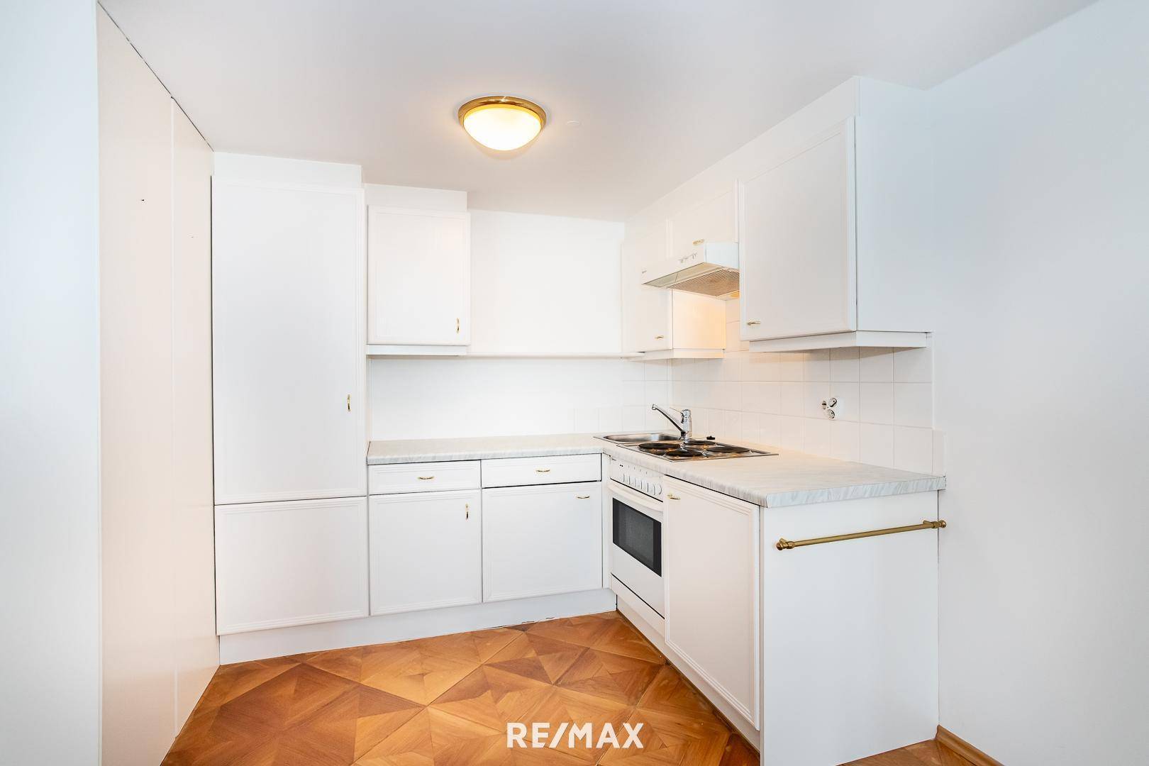 Kompakte weiße Küchenzeile mit Einbaugeräten und ausreichend Stauraum.