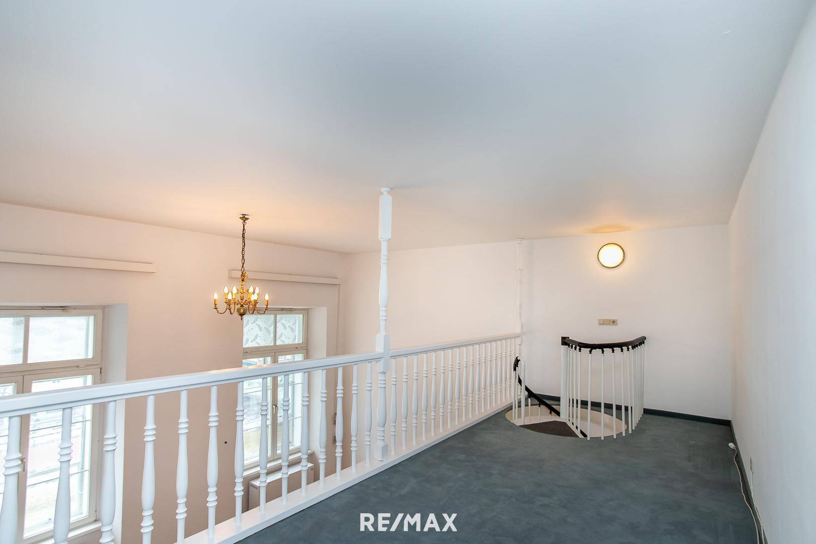 Helle Galerie mit Teppichboden und Zugang zur Wendeltreppe.