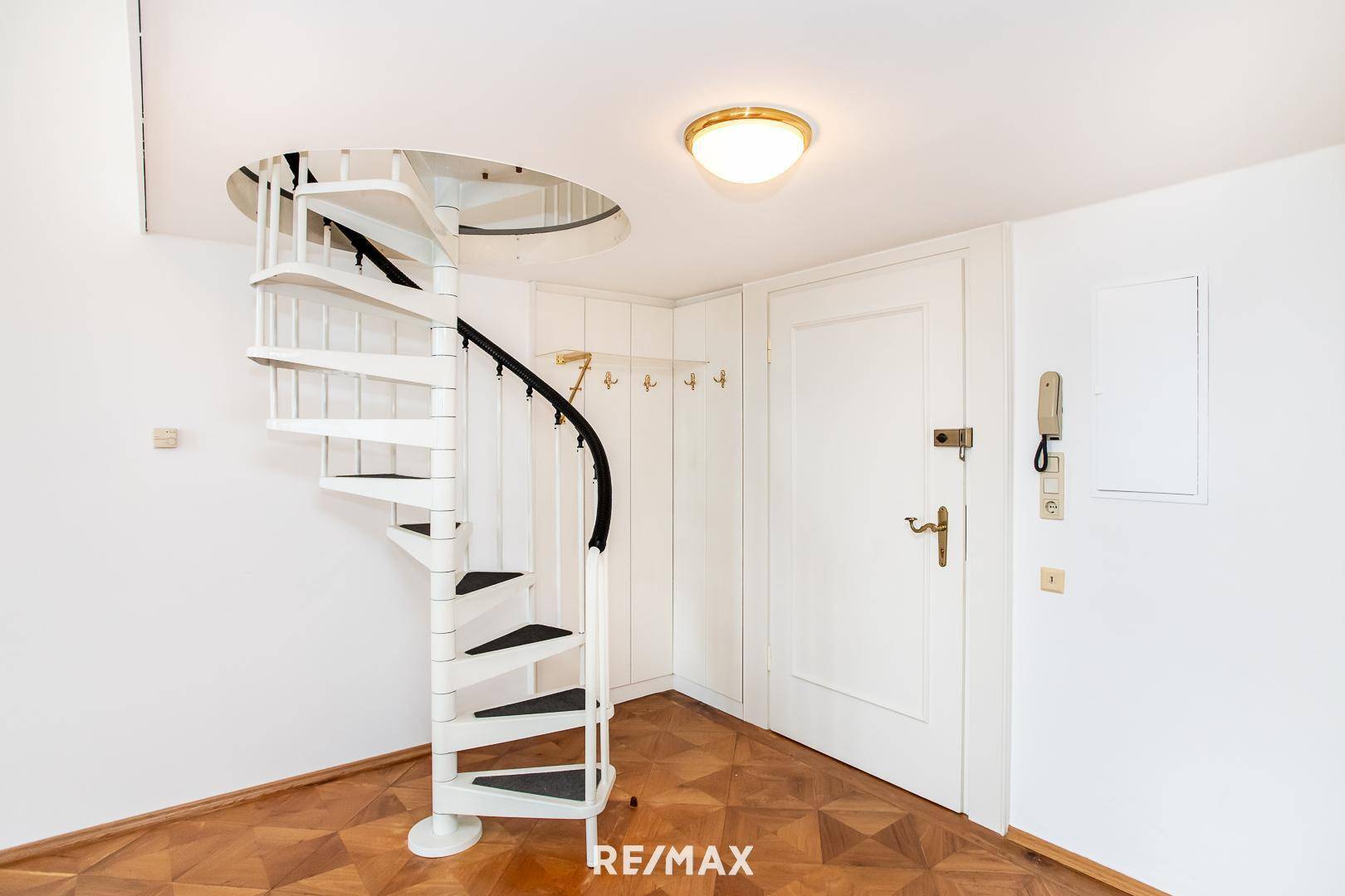 Eingangsbereich mit Wendeltreppe zur oberen Etage und praktischen Einbauschränken.