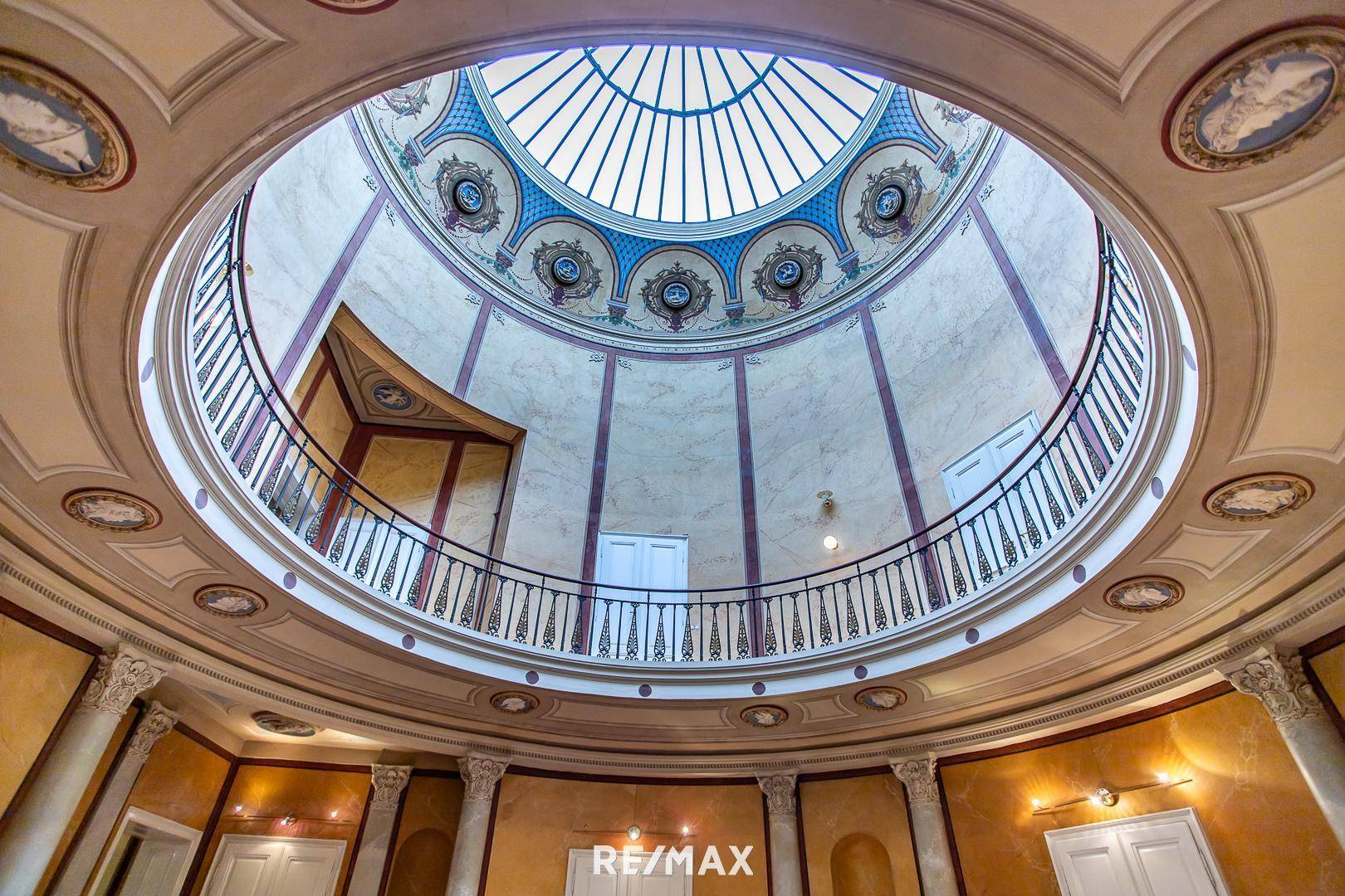 Prächtiges Treppenhaus mit Kuppel, Säulen und kunstvollen Deckenmalereien.