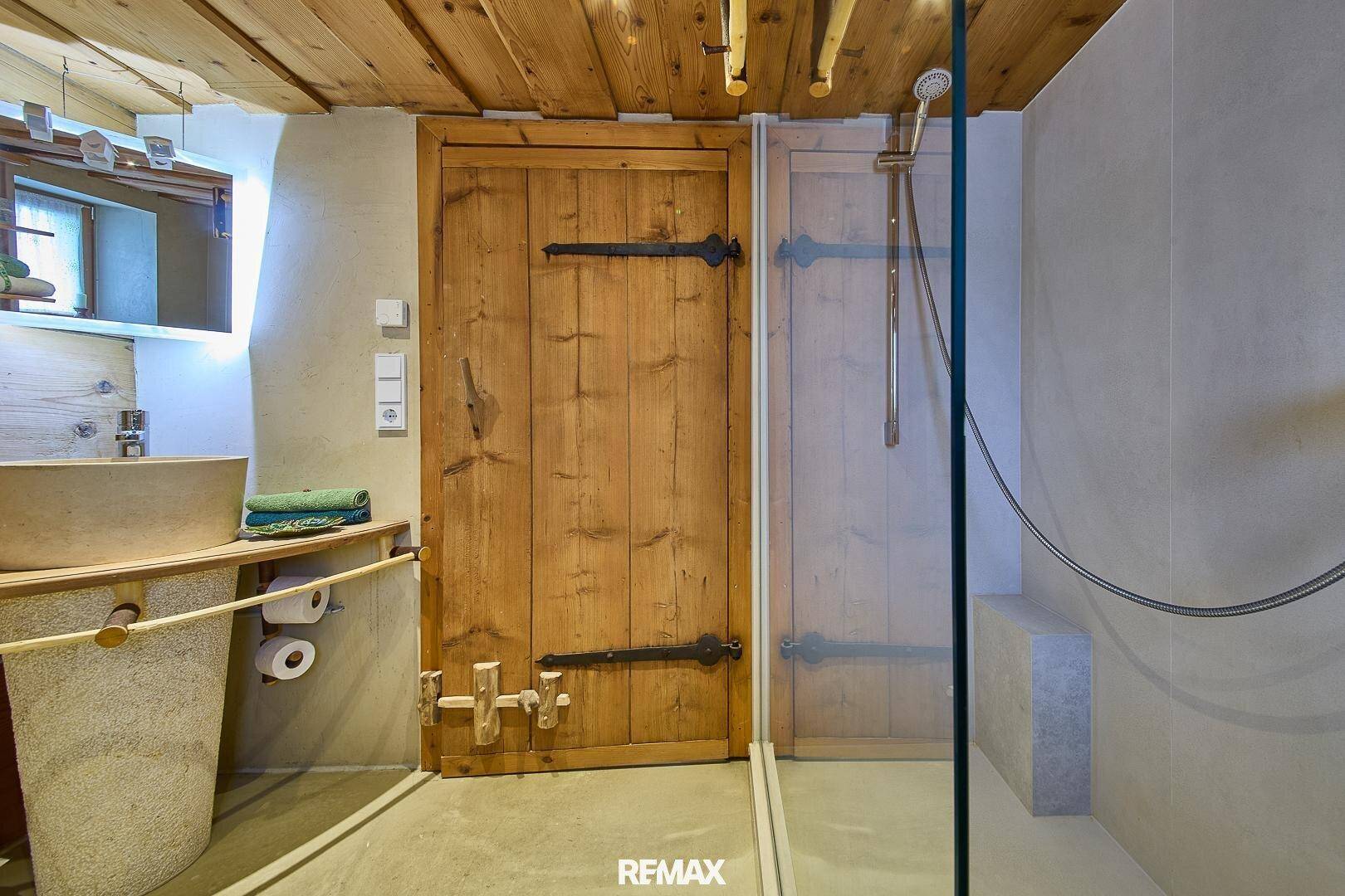 Modernes Badezimmer mit begehbarer Dusche, Holzdecke und rustikalem Holzwaschtisch.