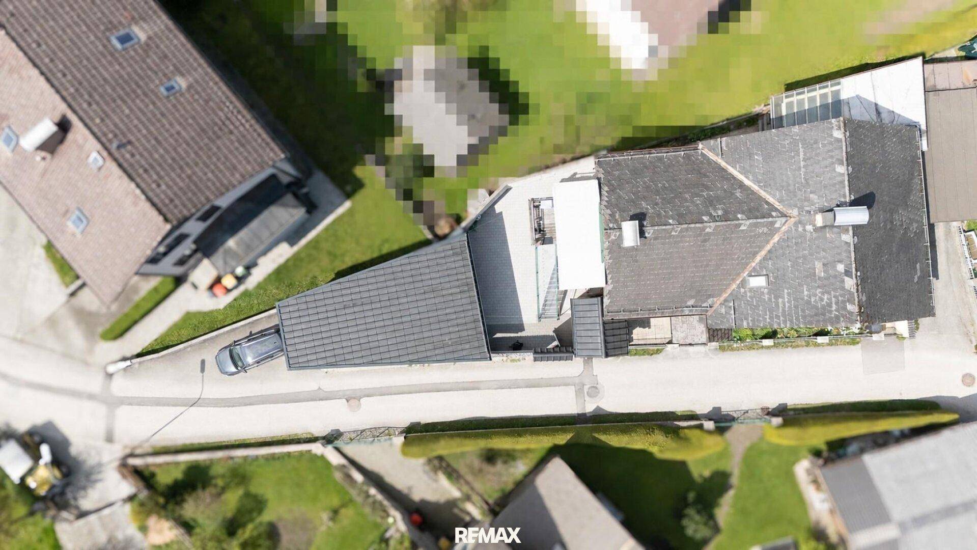 Luftaufnahme des Grundstücks mit Haus, Zufahrt und angrenzenden Gebäuden in ländlicher Umgebung.