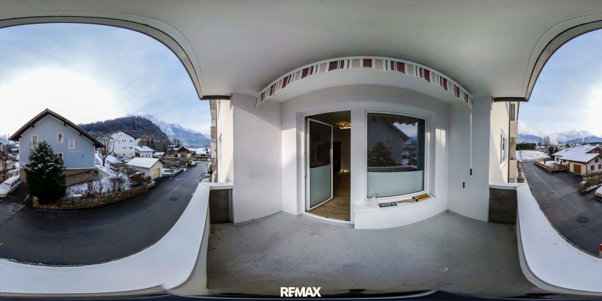 Panoramaansicht vom Balkon mit Blick auf die verschneite Umgebung und die umliegenden Berge.
