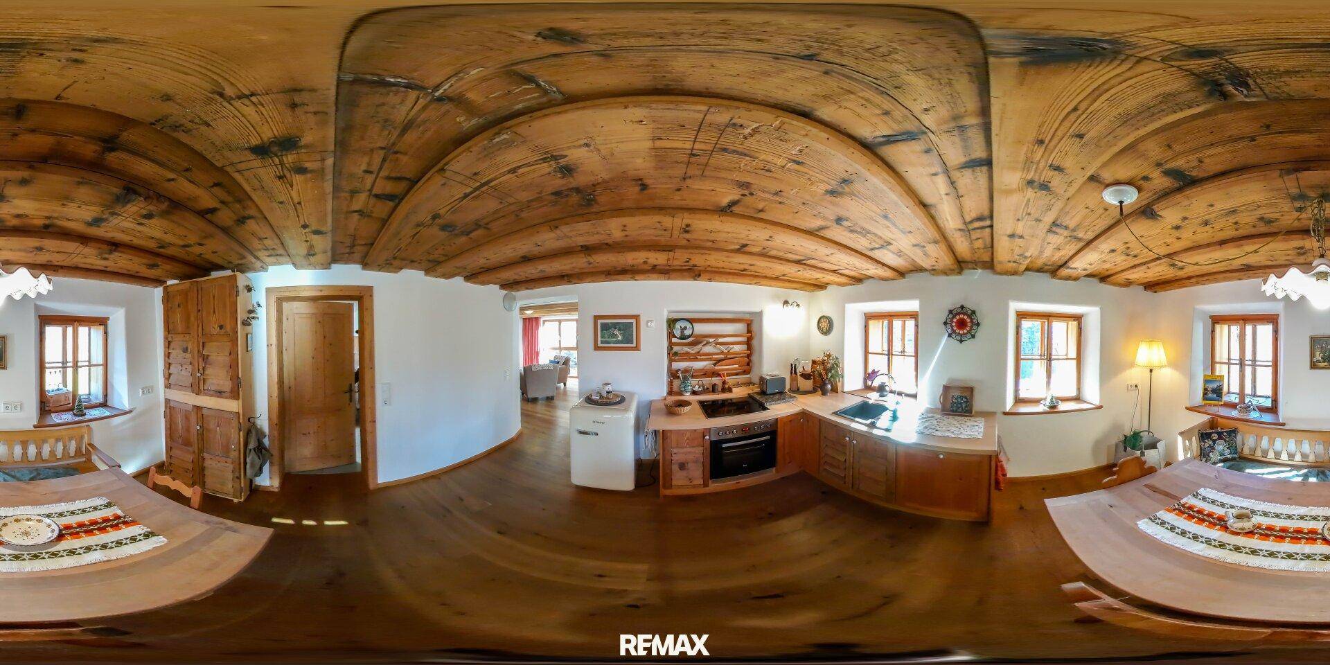 Traditionelle Küche mit gewölbter Holzdecke, Essbereich und rustikalen Möbeln.