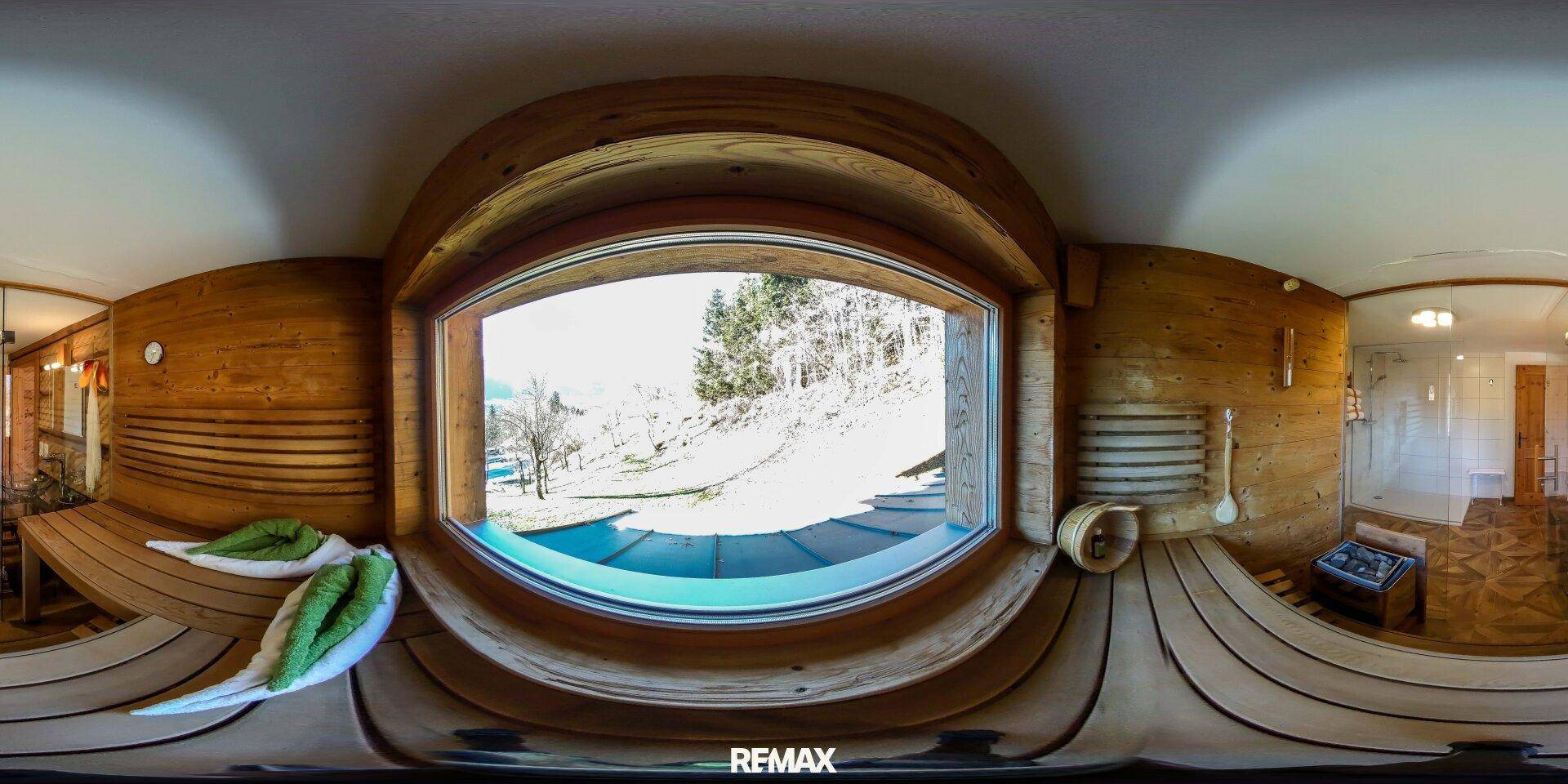 Sauna mit großem Panoramafenster und Blick auf die verschneite Winterlandschaft.