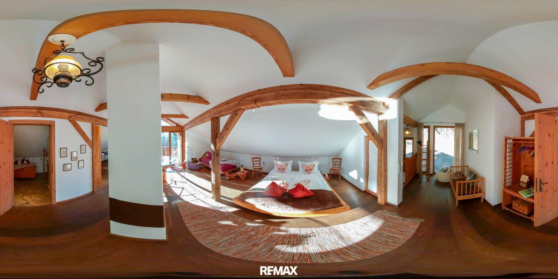 Gemütliches Schlafzimmer im Dachgeschoss mit Holzbalken und schrägen Decken.