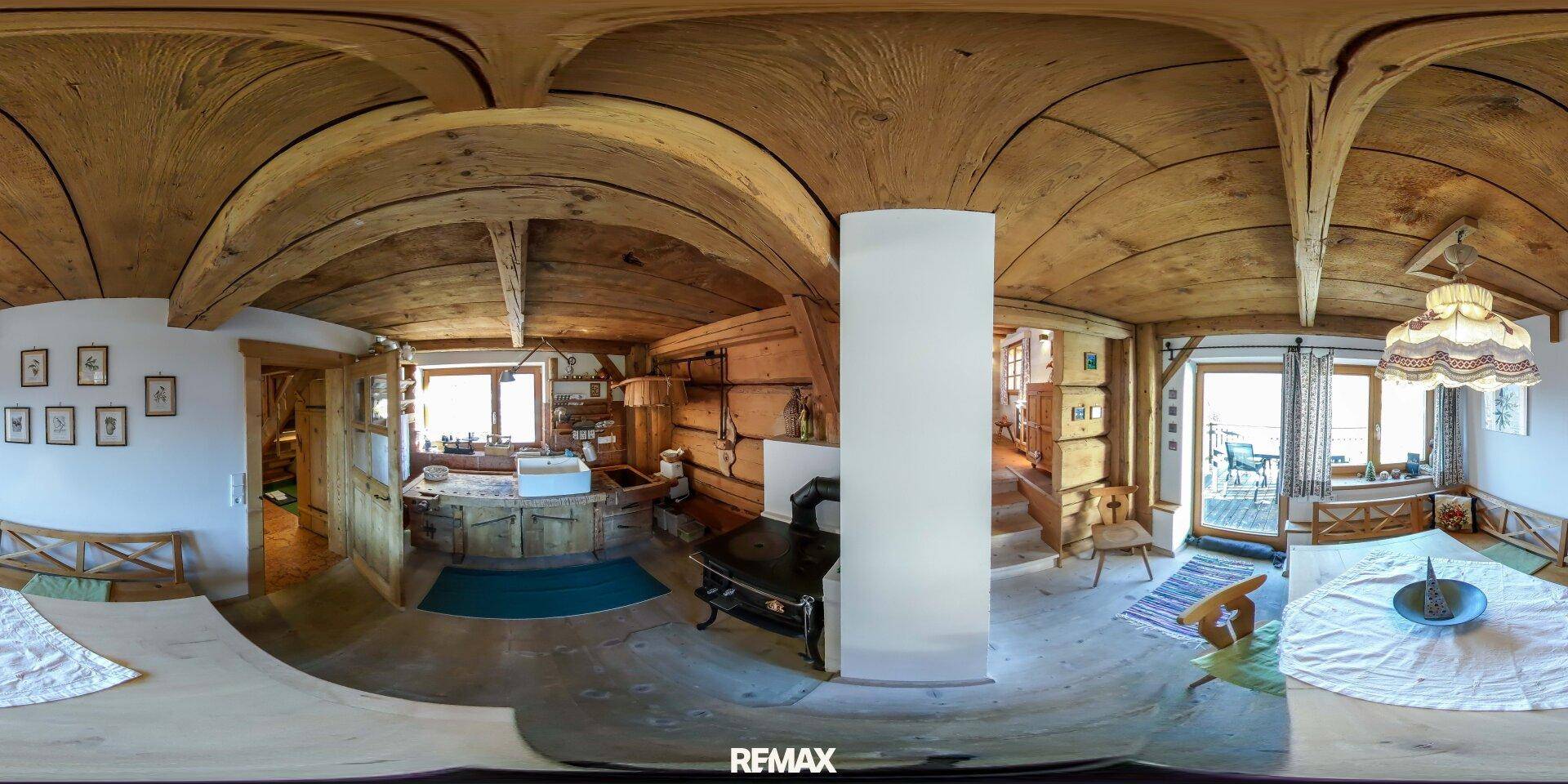 Rustikale Küche mit Holzbalkendecke, Kaminofen und Essbereich in traditionellem Stil.