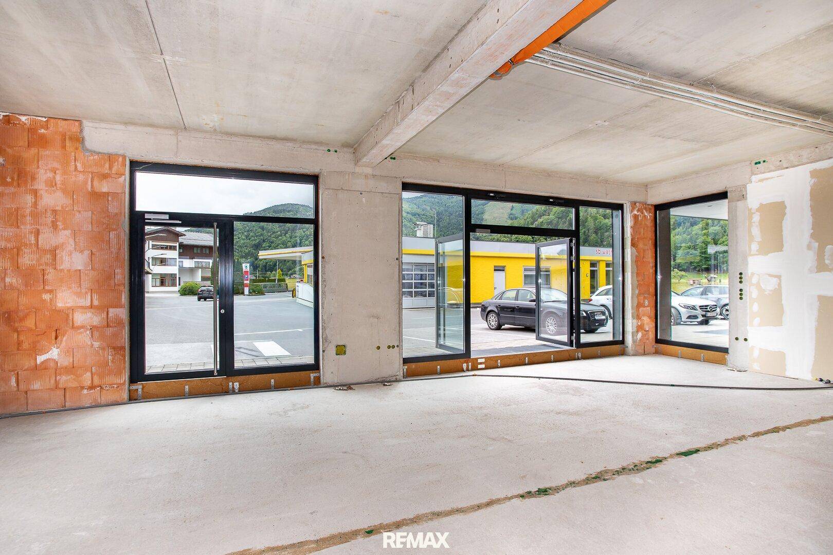 Geräumiger Rohbau mit großen Fensterfronten, die viel Tageslicht hereinlassen und einen Blick nach draußen bieten.