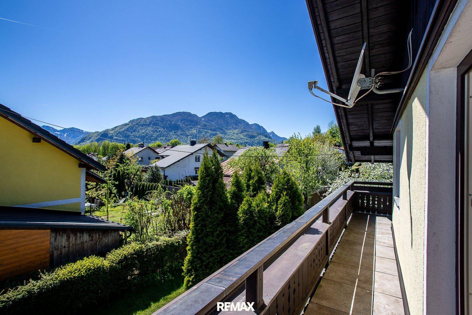Langer Balkon mit Holzboden und weitem Blick auf die umliegende Berglandschaft.