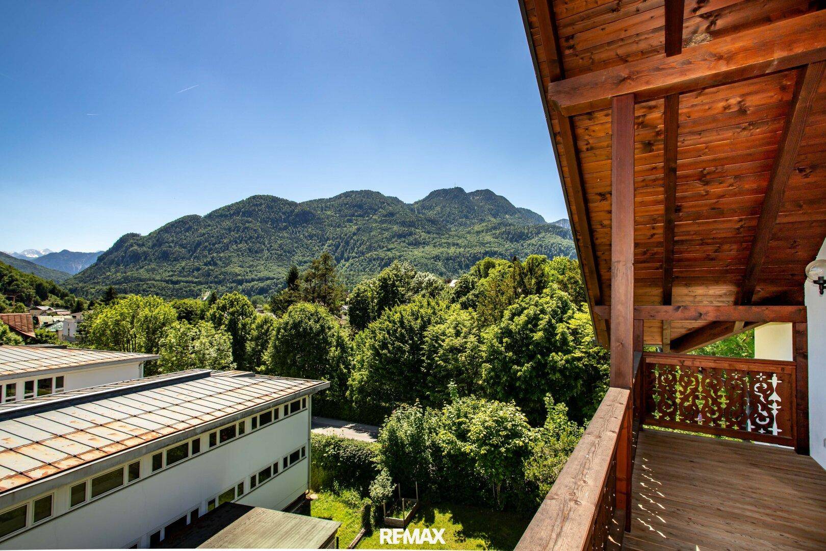 Geräumiger Holzbalkon mit kunstvollen Geländern und weitem Blick auf die umliegende Berglandschaft.