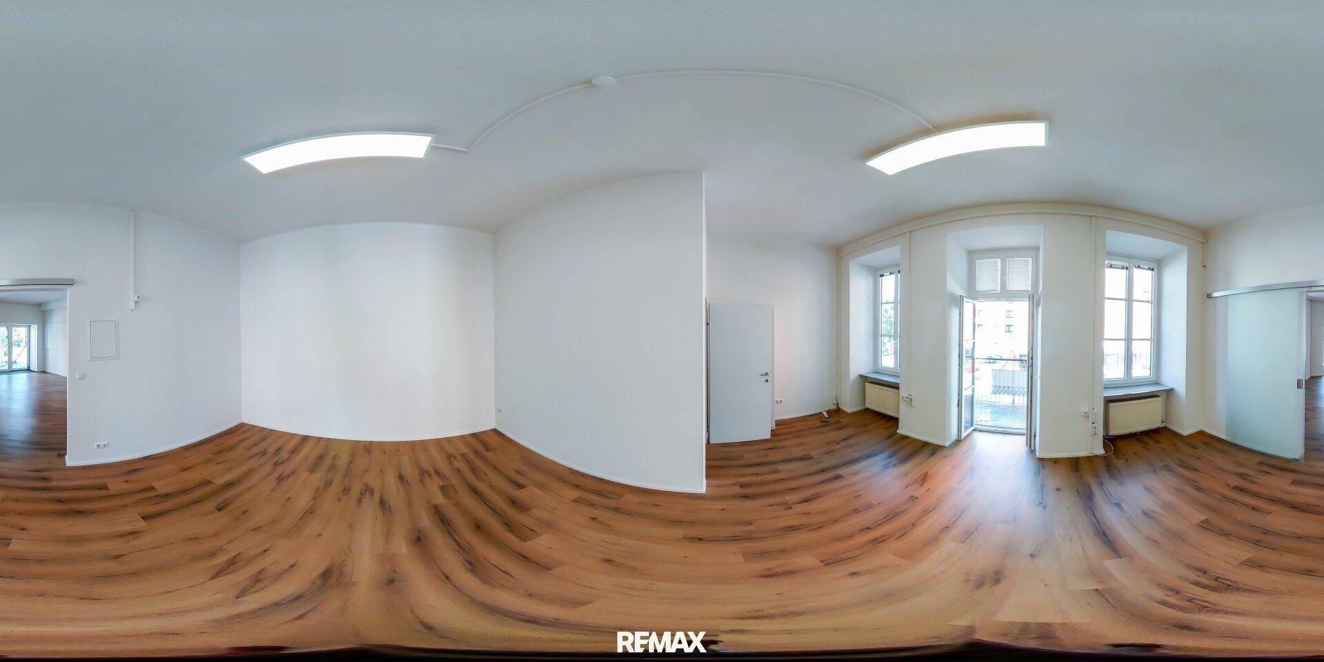 Panoramaansicht eines hellen Raumes mit Holzboden, Fenstern und Schiebetür.