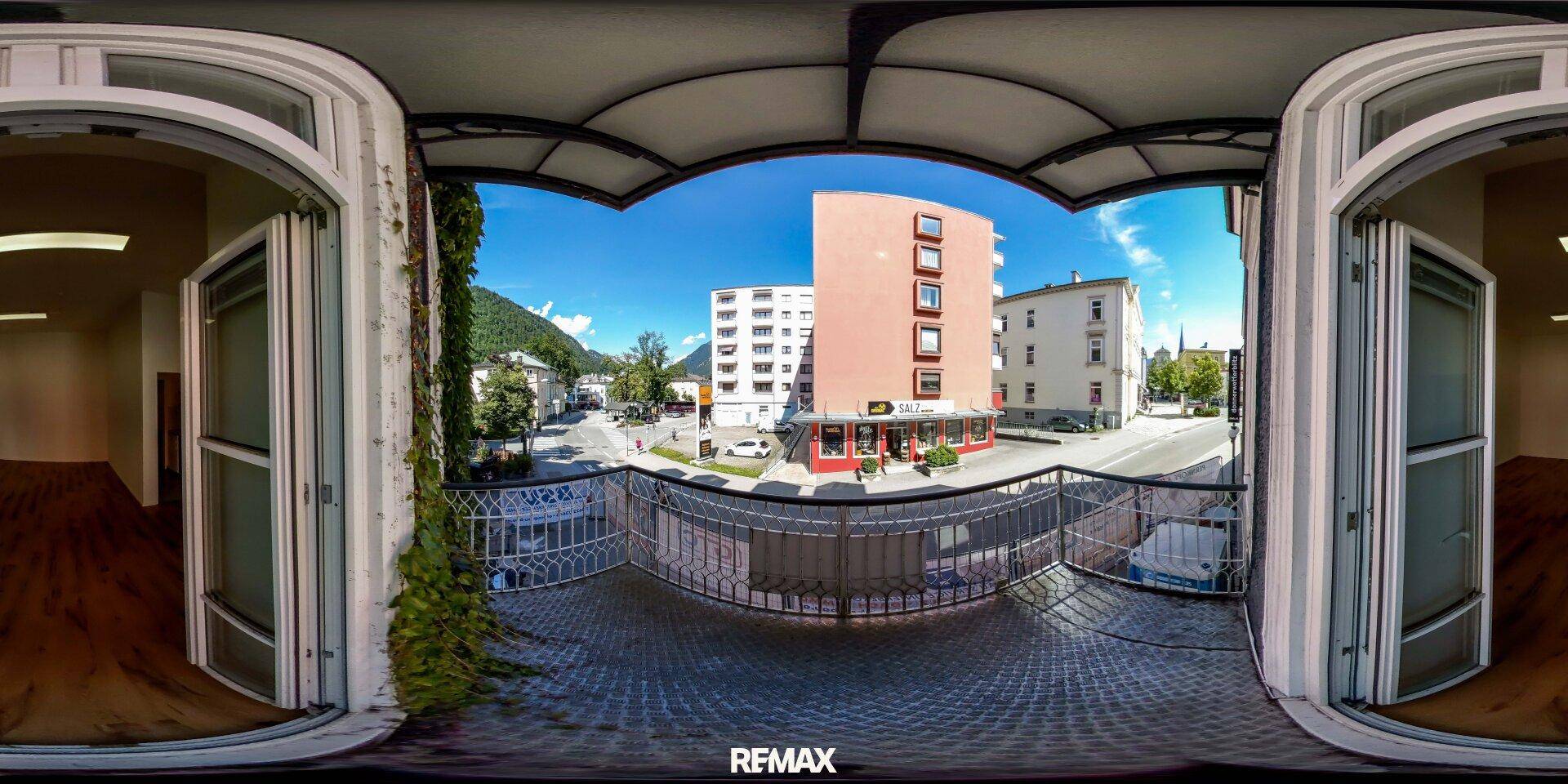 Panoramaansicht eines Balkons mit Blick auf die Straße, Gebäude und Berge.