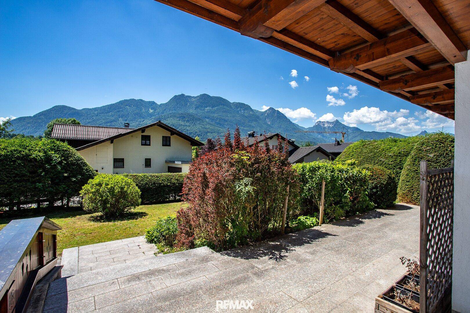 Weitläufiger Blick vom Anwesen auf den gepflegten Garten und die umliegende Berglandschaft.