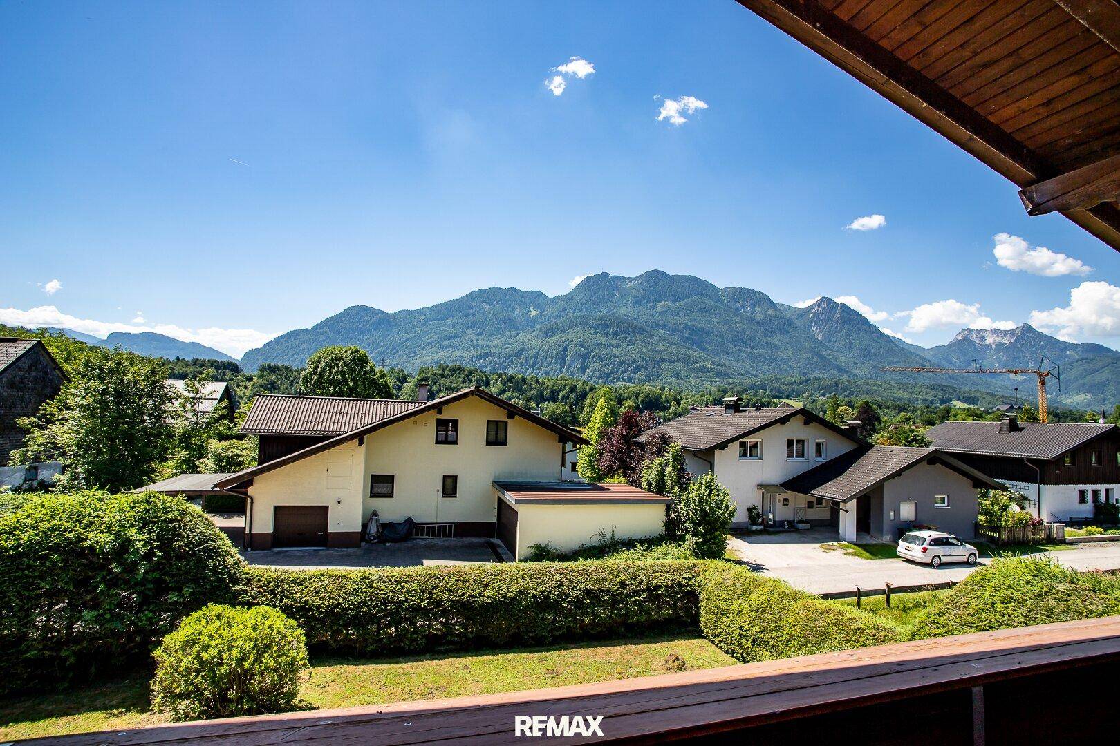Panoramablick von einem Balkon auf die umliegende Wohngegend und die majestätischen Berge.