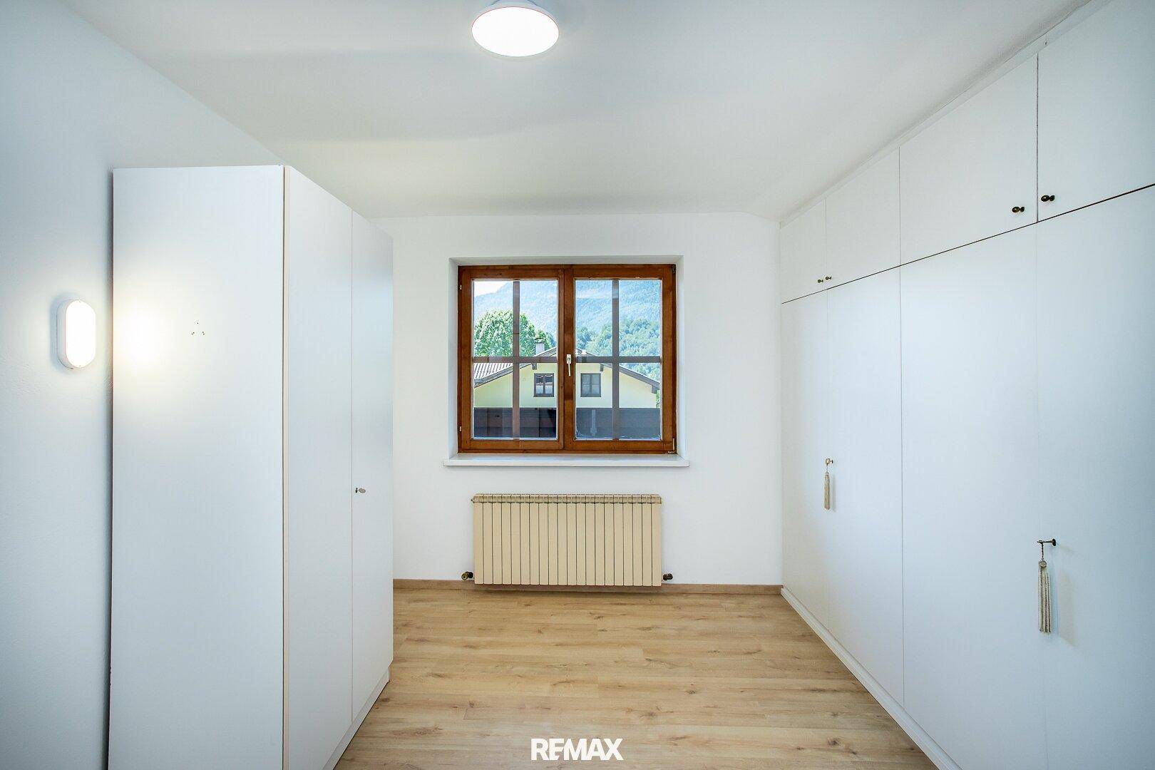 Helles Schlafzimmer mit Laminatboden und praktischen Einbauschränken, bietet viel Stauraum.