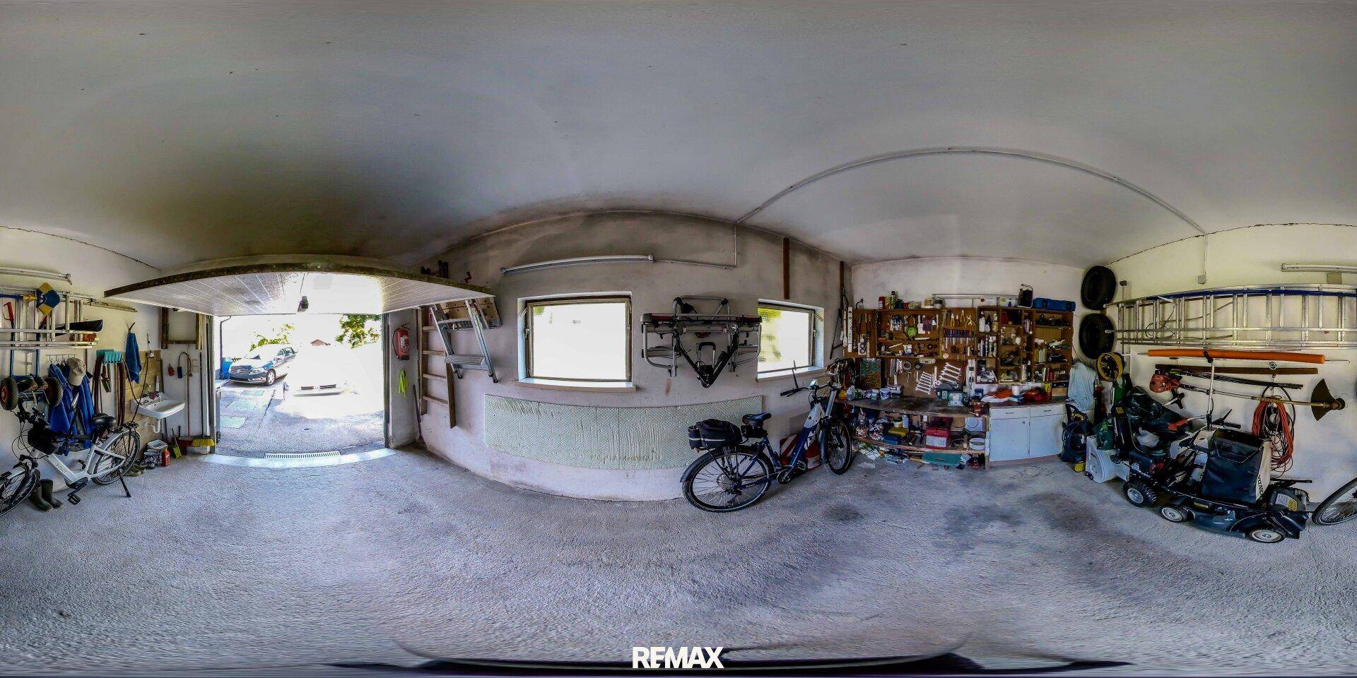 Geräumige Garage mit Werkzeugen, Fahrrädern und direktem Zugang ins Freie.