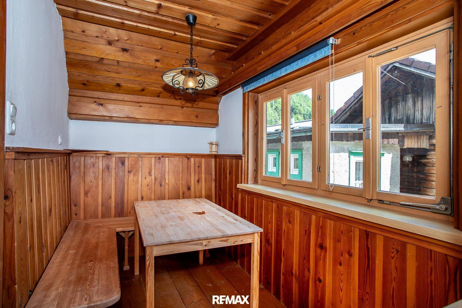 Rustikaler Essbereich mit Holztäfelung, Holzboden und traditionellen Bänken, ideal für gesellige Runden.