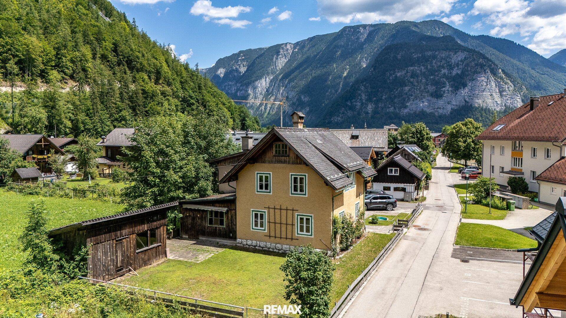 Luftaufnahme des Anwesens in einer malerischen Berglandschaft mit umliegenden Häusern und Straßen.