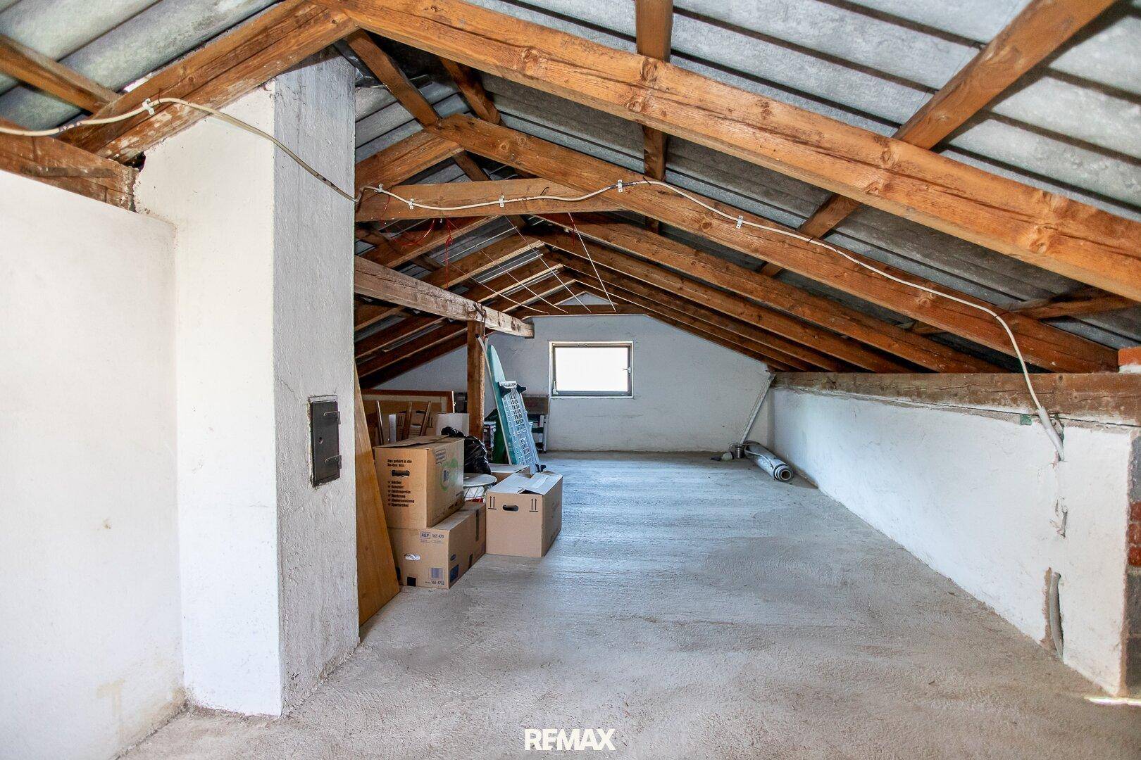 Großer, unausgebauter Dachboden mit sichtbaren Holzbalken und viel Stauraum.
